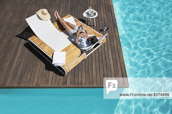 Man relaxing on lounge chair at poolside