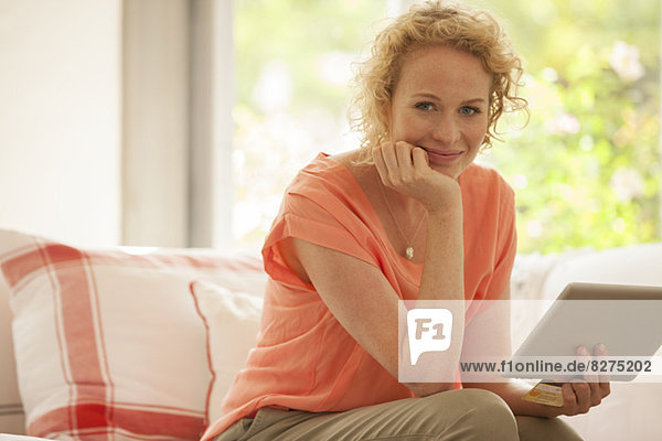 Portrait of woman using digital tablet on sofa