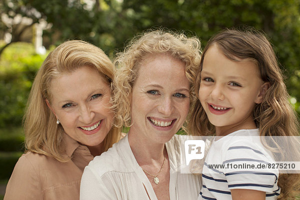 Drei Generationen von Frauen lächeln im Freien