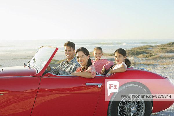 Family in convertible at beach