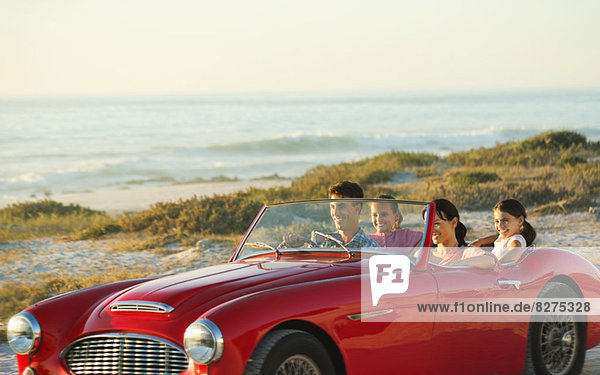 Family in convertible on beach