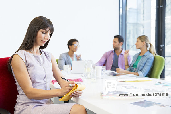 Businesswoman taking notes in meeting
