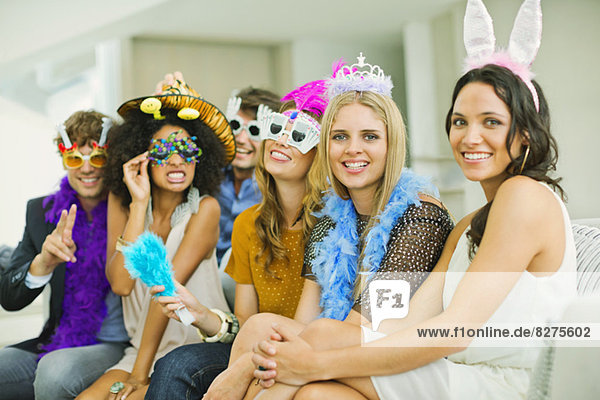 Freunde mit dekorativen Brillen und Kopfbedeckungen auf der Party