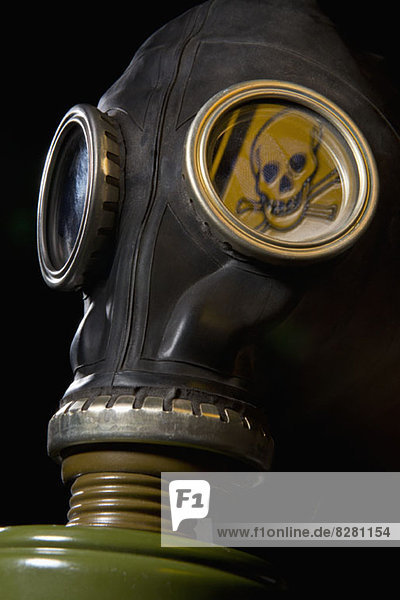 Eine Gasmaske mit einem Totenkopf und einem Warnschild in der Maske.