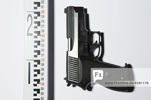 Eine Handfeuerwaffe neben einem Lineal