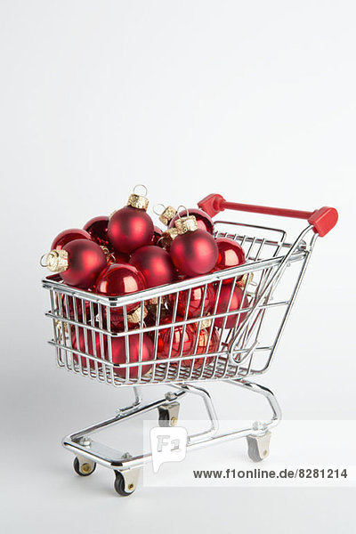 Ein Einkaufswagen voller roter Ball-Feiertagsschmuck