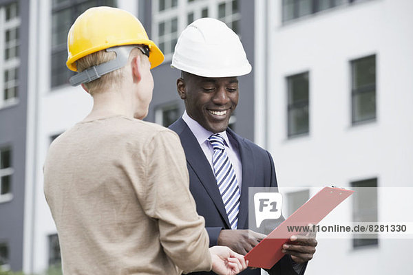 Businessman happily giving directions to manual worker