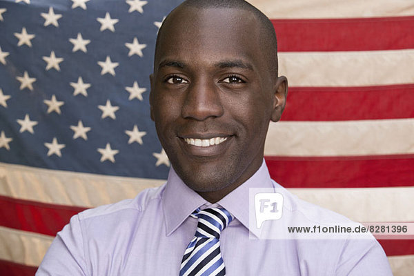 Smiling man in front of American flag