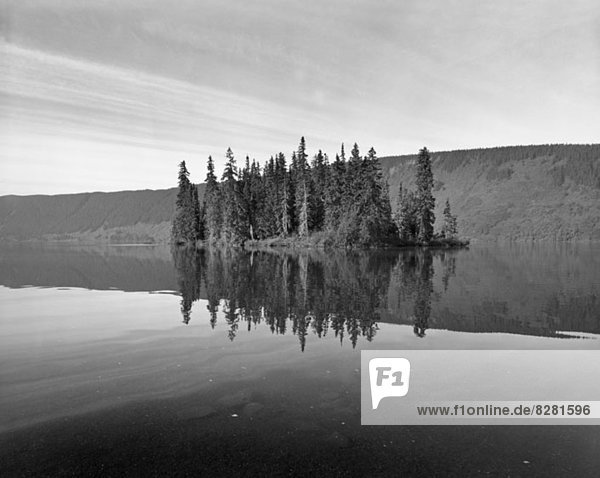 Reflection of cliffs and trees in Meziadin Lake British Columbia Canada