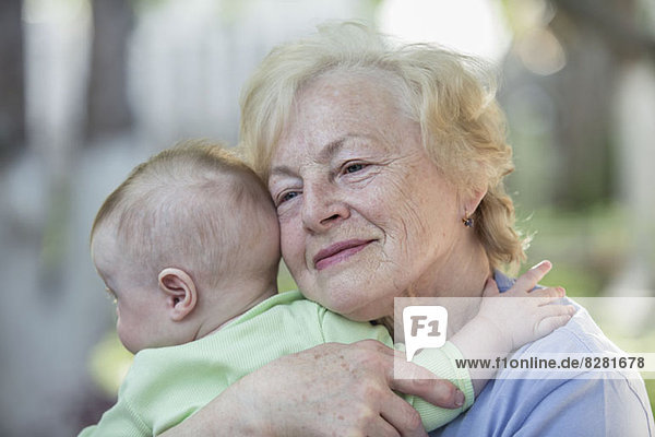 Eine Großmutter  die ihren Enkel umarmt.