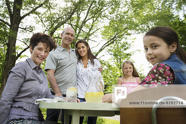 Eine Sommer-Familienzusammenkunft auf einem Bauernhof. Eine Familiengruppe  Eltern und Kinder. Herstellung frischer Limonade.