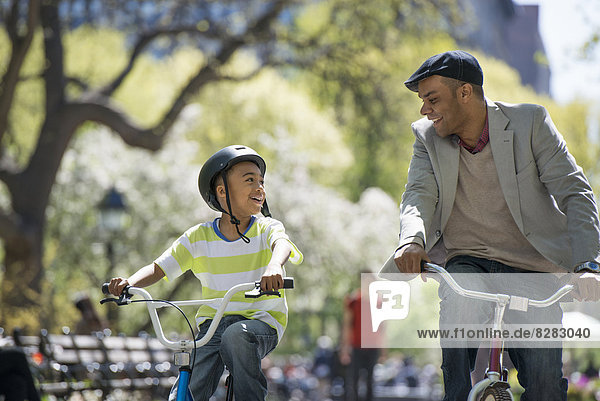 Bicycling And Having Fun. A Father And Son Side By Side.