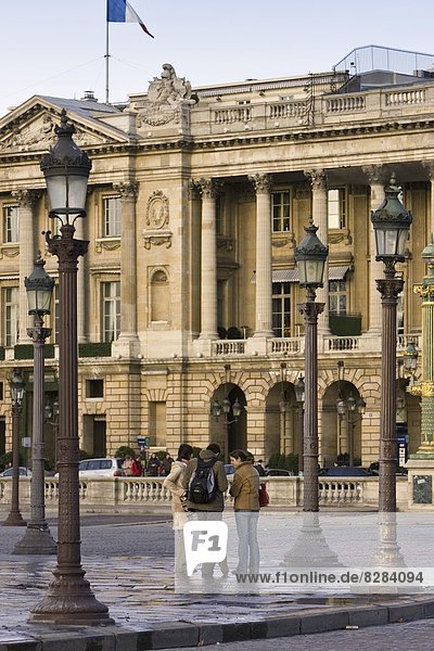 Tourists talking on street corner in front of Hotel de Crillon in Place de la Concorde  Central Paris  France