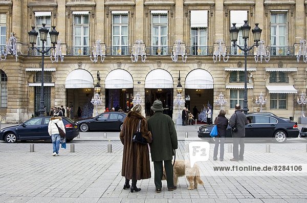 Couple with dog gaze at Ritz Hotel in Place Vendome  Central Paris  France