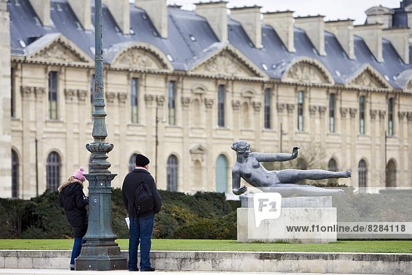 Visitors admire bronze sculpture statue of reclining nude by Maillol in Jardin in front of the Louvre in the Jardin des Tuileries  Central Paris  France