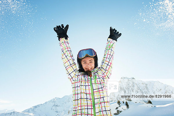 Porträt einer jungen Skifahrerin mit erhobenen Armen  Les Arcs  Haute-Savoie  Frankreich