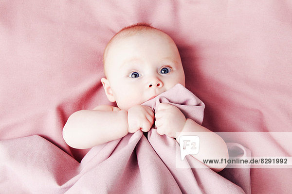 Baby girl on pink blanket