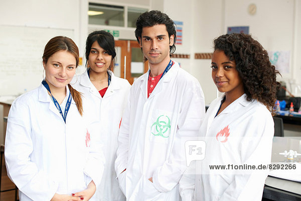 Portrait of four college students wearing lab coats
