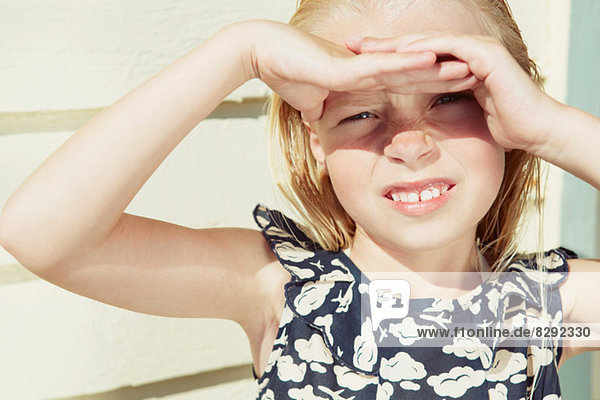 Kind bedeckt die Augen vor Sonnenblendung