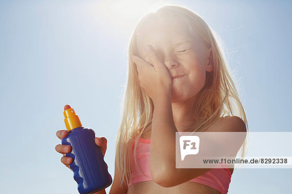 Mädchen mit Sonnencreme im Gesicht