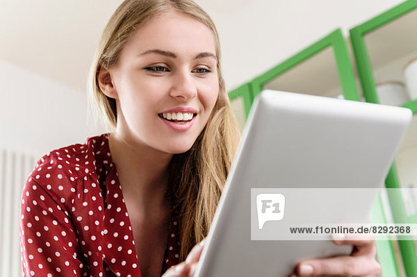 Mädchen lächelt auf digitalem Tablett