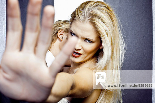 Close up of young angry woman with hand in front of camera