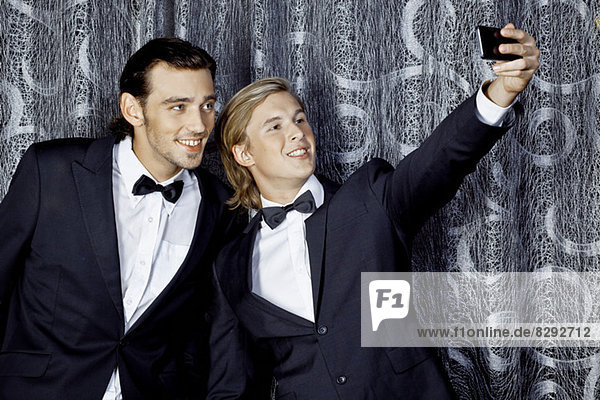 Zwei junge Männer beim Selbstporträt auf dem Handy