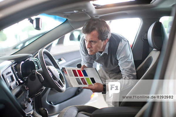 Mid adult man with color swatch in car showroom