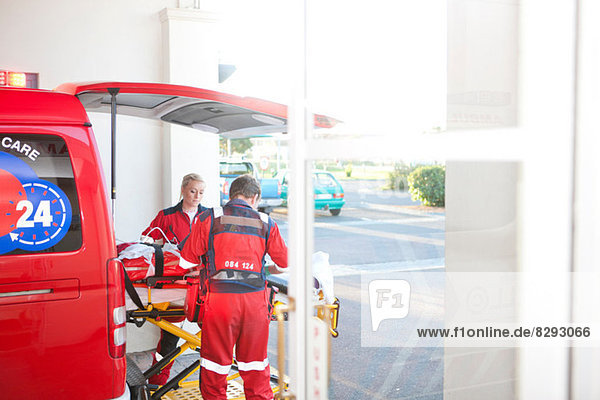 Rettungssanitäter verlegen Patienten vom Krankenwagen ins Krankenhaus