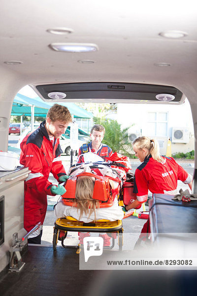 Rettungssanitäter heben den Patienten in den Krankenwagen