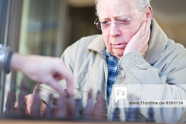 Senior Mann spielt Schach mit Sohn