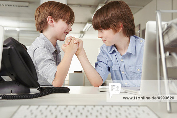 Zwei Jungen Armdrücken im Büro