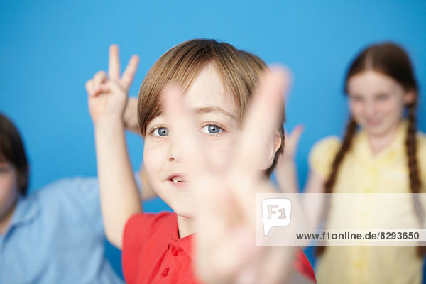 Portrait of boy making peace sign