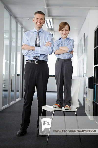 Father and son in office  boy standing on chair
