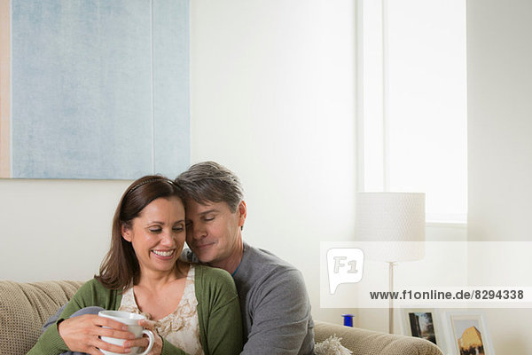 Mature couple sitting on sofa  woman with coffee