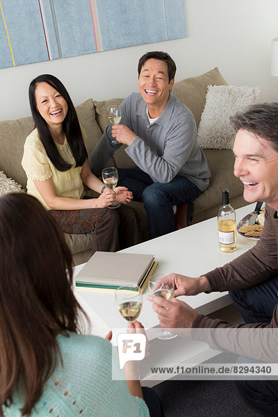 Reife Freunde treffen sich mit Weißwein