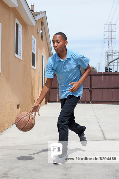 Junge hüpfender Basketball im Hof