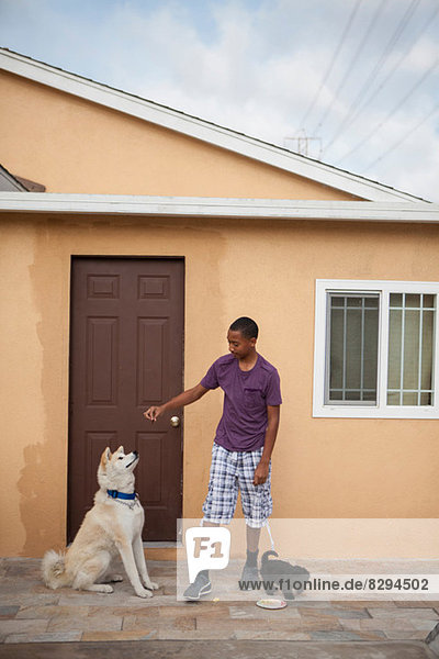 Junge vor dem Haus mit zwei Hunden