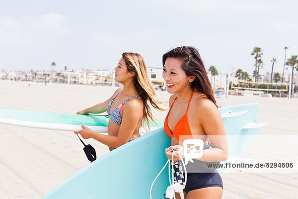 Female friends carrying surf boards  Hermosa Beach  California  USA