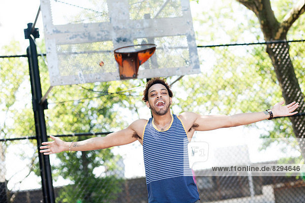 Junger Mann feiert auf dem Basketballplatz
