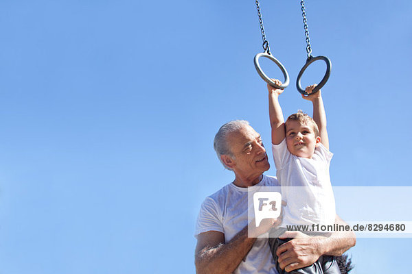 Großvater hält Enkel auf Gymnastikringen