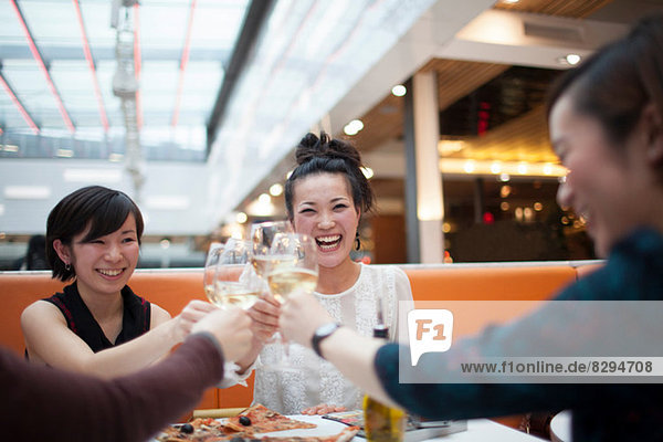 Young women toasting with wine in restaurant