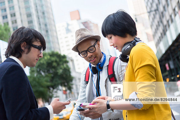 Three friends on street with mp3 player