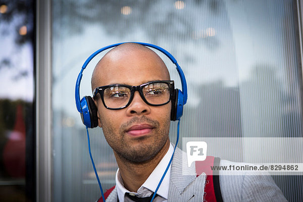 Portrait of young man with shaved head wearing headphones