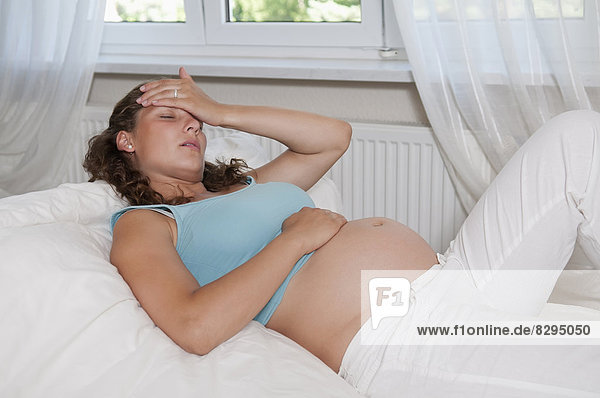 junge schwangere Frau mit Kopfschmerzen