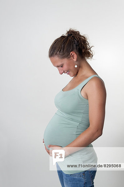 Smiling young pregnant woman  studio shot