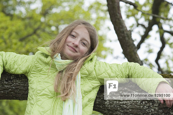 girl leaning at a branch of a tree