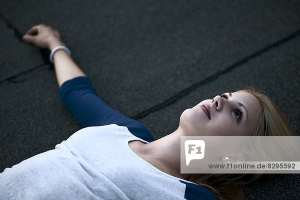 Young woman lying on flat roof