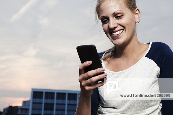 Smiling young woman with smart phone