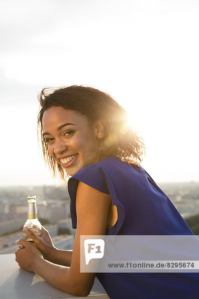 Young woman looking at view  holding beer bottle